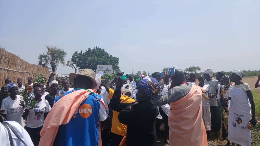 Community members welcoming the delegation outside the Women and Girls Friendly Space