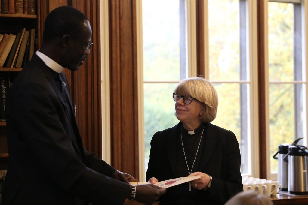 A document is handed over between two church leaders during the meeting at Lambeth Palace