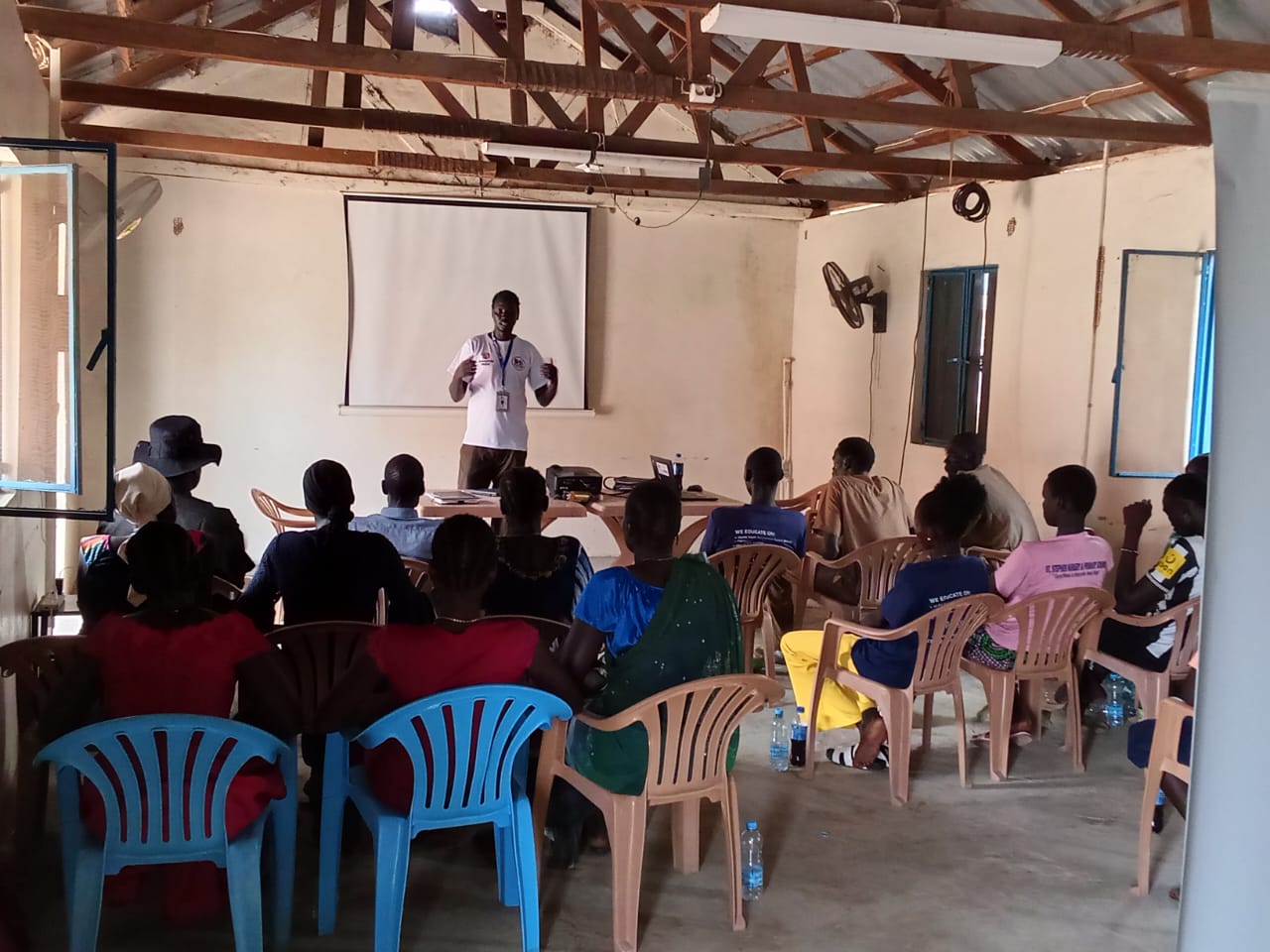 HRSS facilitator presenting to seated AAP committee members in Leer County