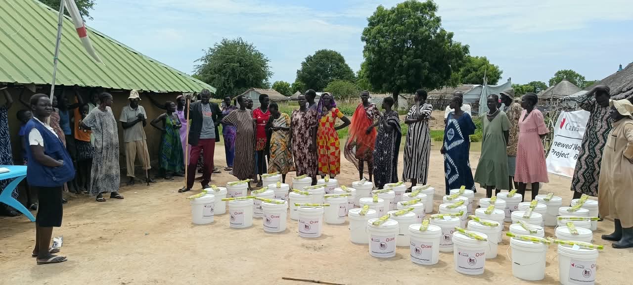 Participants gather around the WASH items during the distribution.