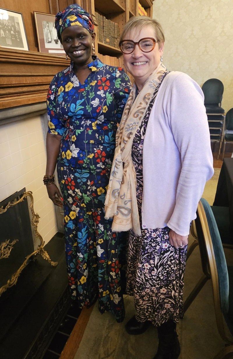 Angelina Jial smiling beside a fellow participant in a wood-panelled room at Lambeth Palace