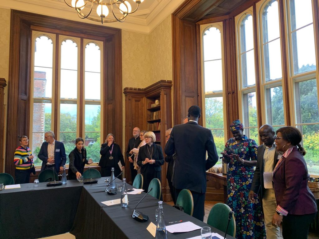 Participants gather beside the meeting table in the library at Lambeth Palace